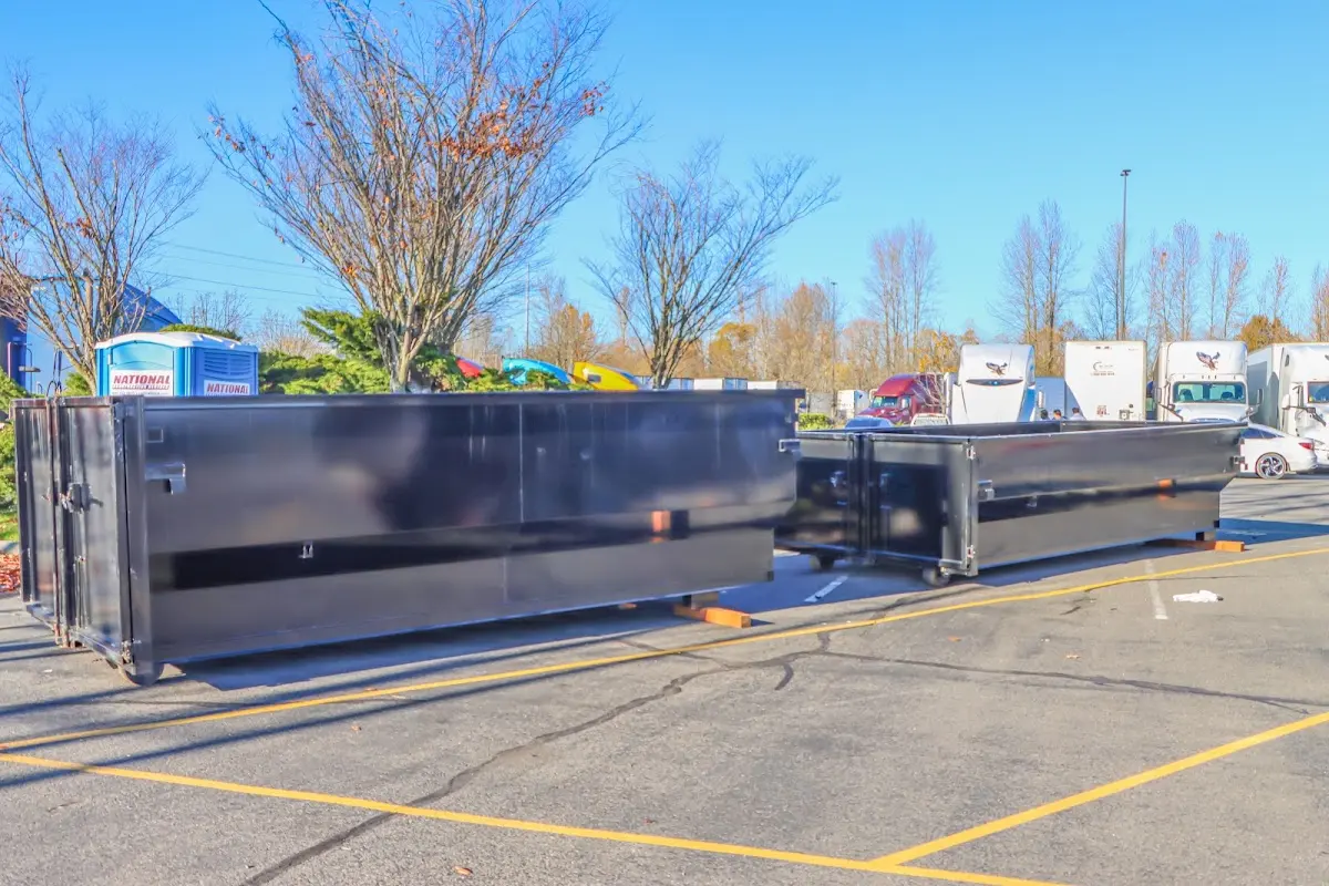 Professional dumpster rental service with roll-off container on residential driveway in Plum